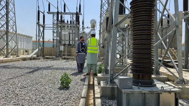 ICRC's Water and Habitat staff - Ahmad Zia Abdali (on the left) - assessing the power line to the Mirwais Regional Hospital with an official from Afghanistan’s electricity company.