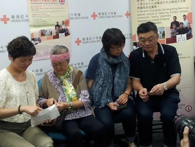 黄氏家庭在互相分享丁兰儿时的照片。(由左至右)黄丁兰、丁兰母亲、丁兰姐姐及弟弟。