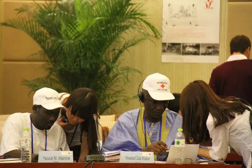来自苏州大学的志愿者正在帮来自乍得的代表调试同声翻译机。女孩们表示她们很高兴可以参加这次活动并贡献出自己的一份力量。