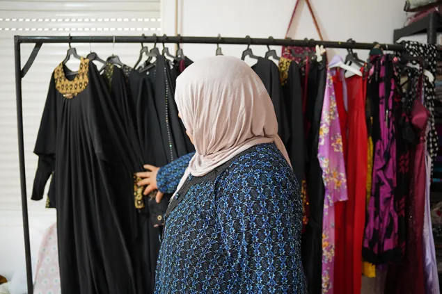 Aziza looking through a rack of clothing