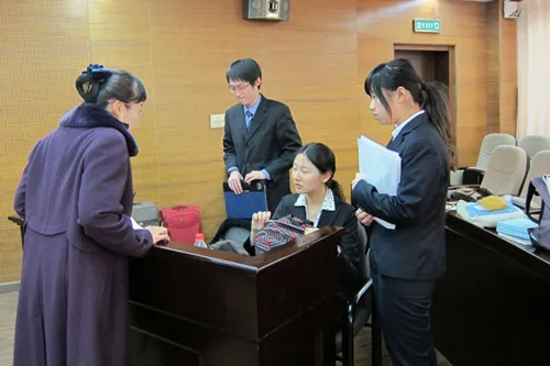 半决赛后，北京大学的易平老师（左一）正在给队员们分析失利原因。同时，她也表示能够取得这样的成绩已属不易； 而她陪伴同学们的脚步只能走到这里，因为下午她将前往荷兰，带队参加另一场有关国际人道法的比赛。无缘决赛的北京大学队将在没有教练的情况下参加下午争夺第三名的比赛。