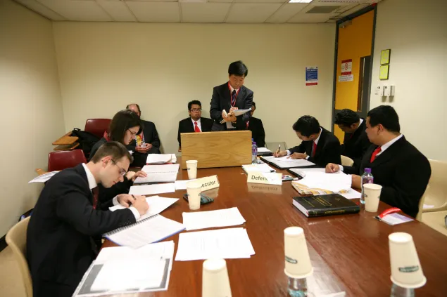 在香港进行的国际人道法模拟法庭比赛上，来自澳大利亚国立大学毕业班的学生肯德拉•富拉克和约瑟夫•克拉姆（左）作为控方选手与来自印度尼西亚加札马达大学代表队的学生展开辩论。