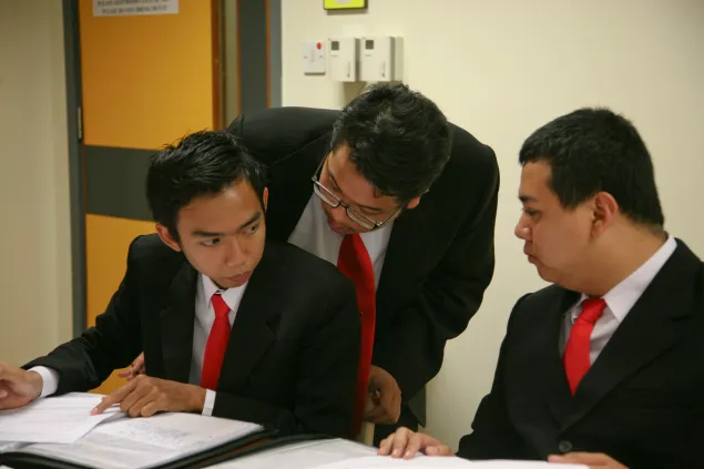 在2011年亚太地区国际人道法模拟法庭比赛中，来自加札马达大学的里兹基•维拉特托洛（左）与他的队员就案例进行讨论。