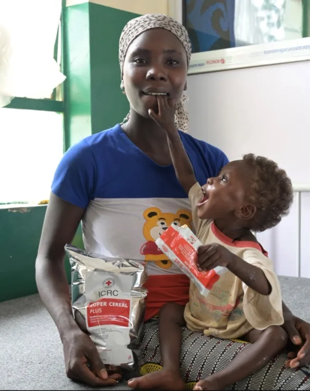 Nigeria Sabina's mother holding the young child on her lap