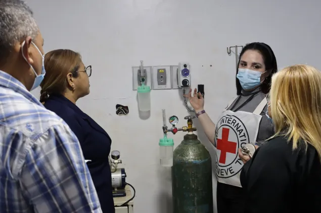 Una trabajadora del CICR le explica al personal de salud del hospital de El Callao, cómo hacer el mantenimiento al sistema de gases medicinales