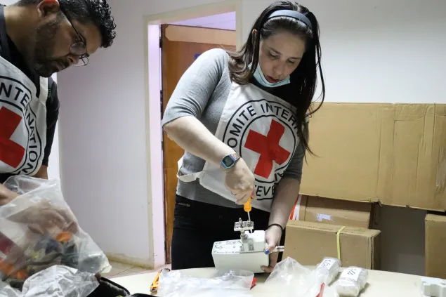 Dos trabajadores del CICR están armando unos equipos que donaron para el hospital de El Callao
