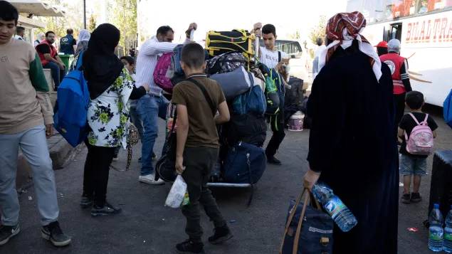 Zakieh and her family carrying their things to leave the borders