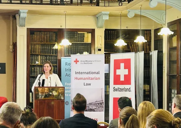 An ICRC colleague speaking behind a lectern 