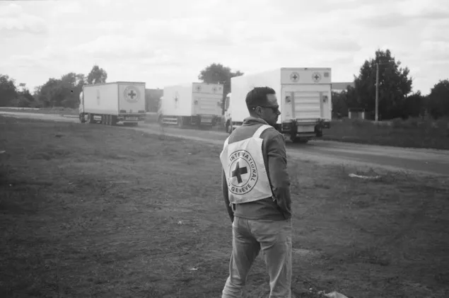 The distribution of briquettes in the village of Pidlyman ICRC staff looks on as ICRC trucks passed on the road during a distribution of briquettes in the village of Pidlyman.