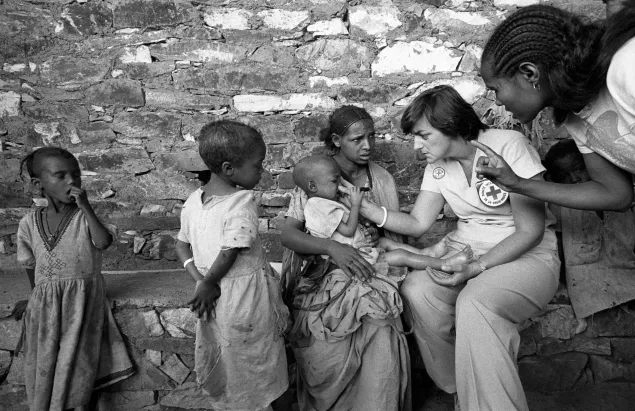 1985-03-28 Axum, Ethiopia,  New Zealand Red Cross nurse examining a baby girl. She is 3 years old and suffers from marasmus and kwashiorkor.