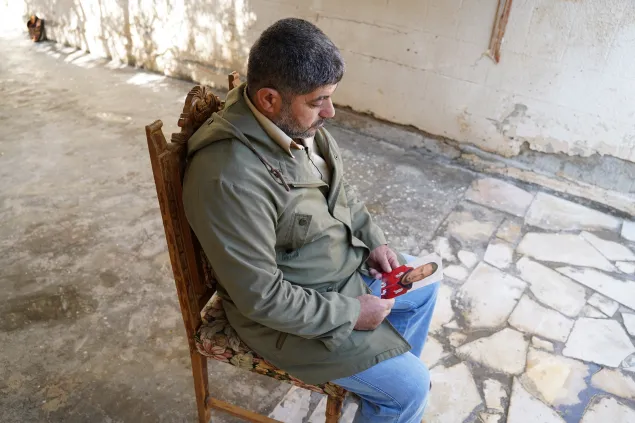 A man holds a picture of his brother