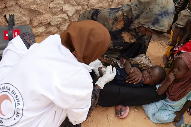 An SRCS nurse immunizes a child in Xaaro village 