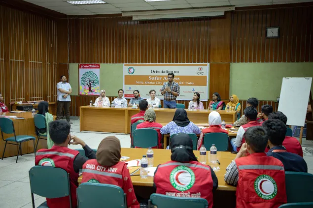 ICRC and Red Crescent societry staff seated in a classroom with the picture taken from the back