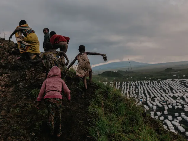 Los niños escalan las laderas del cráter de un volcán extinto sobre el campamento de Lushagala