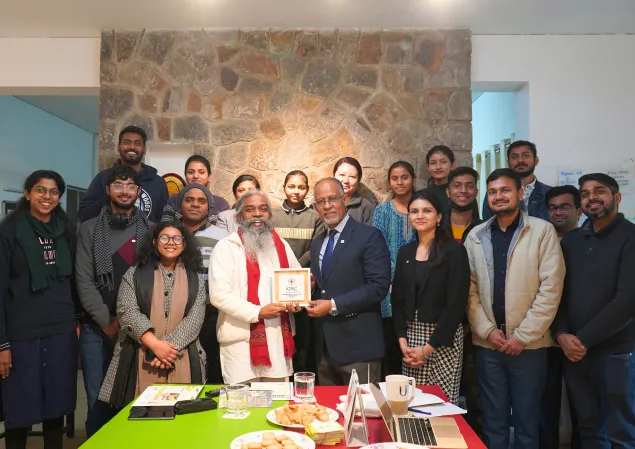 A group photo of people at an event, where head of the ICRC’s regional delegation in New Delhi hands over a memento to the director of CURE India.
