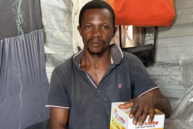 A man in Haiti with a solar lamp he received.