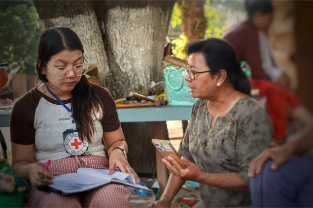 An ICRC worker with a woman in Myanmar