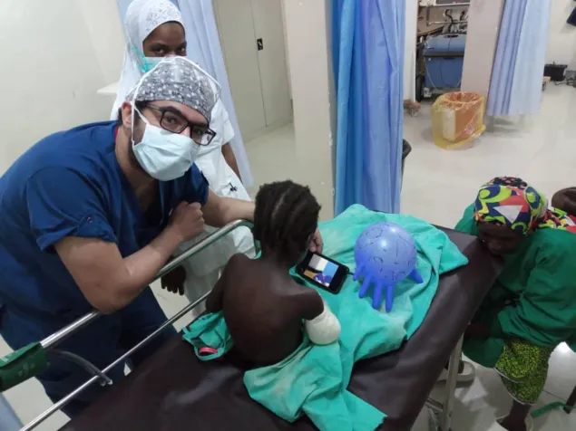 Dr. Aktham Al-Farnawani with a child with a gunshot wound to her arm before entering the operating room in Maiduguri.