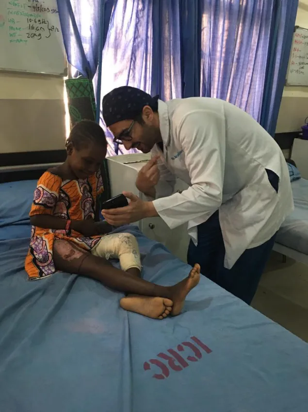 Dr. Aktham Al-Farnawani with a girl who suffered a broken thigh as a result of a gunshot in Maiduguri.