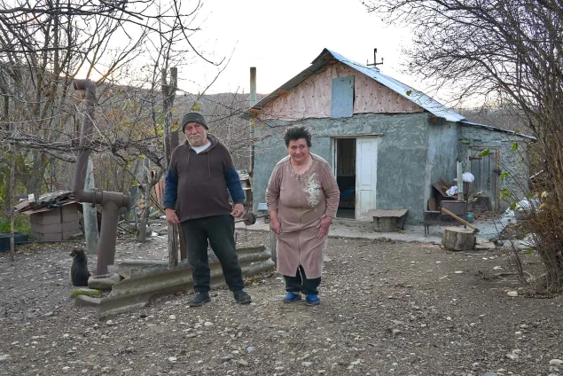 Sona and her spouse in their garden where they grow beans and apples to support their small household