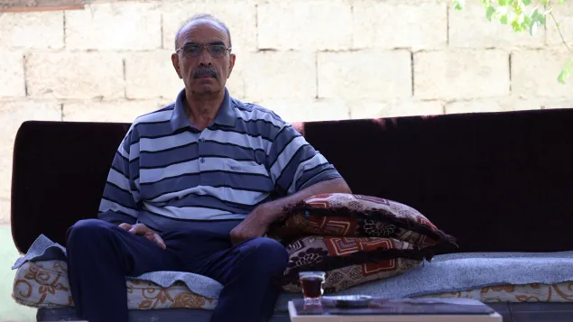 Mohammad sits on a sofa looking directly into the camera