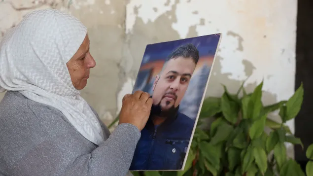 Um Mohammad looks at a picture of her son