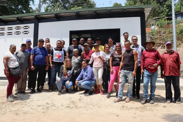 Personas de la comunidad junto a trabajadores del CICR posan para una foto afuera de la caseta de bombeo en Magdaleno
