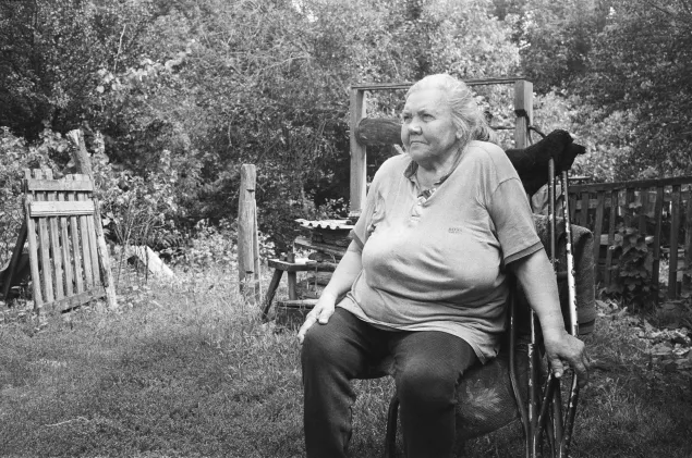 Valentyna Nazaruk sitting in front of the dry well at her home in Sukha Kamianka.