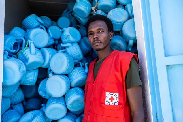 Allamine Saleh, 37, volunteer with the Red Cross of Chad, stands among some of the items distributed by the ICRC and the Red Cross of Chad in Tiné, Wadi Fira, Chad.