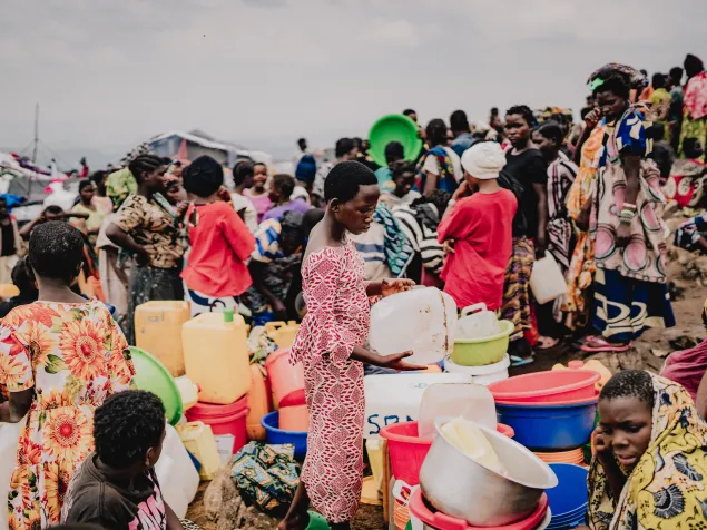 Congolese refugees in the Busuma camp queue to use a water pump. 