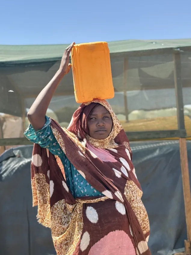 Réfugiée soudanaise avec un bidon d'eau sur la tête à Adré
