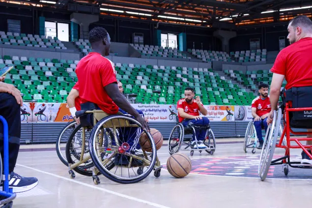 Wheelchair basketball players train together on an indoor court in Libya as part of an ICRC-supported physical rehabilitation and inclusion programme.