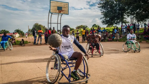 Une personne vivant avec handicap joue au basketball sur fauteuil roulant