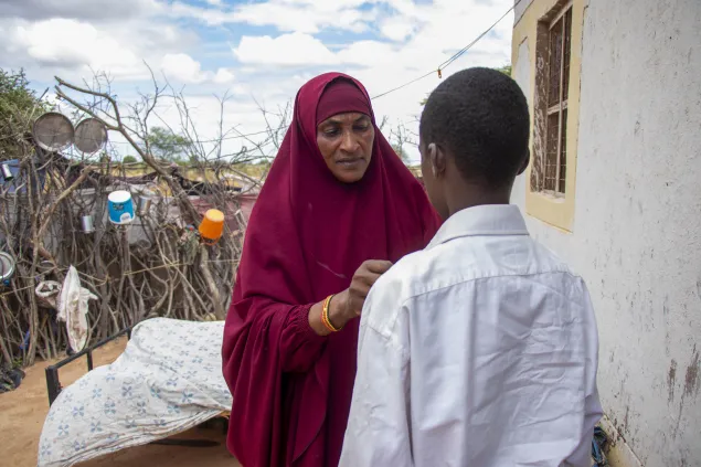 Zeinab, a beneficiary of the Ecosec program prepares her son for school