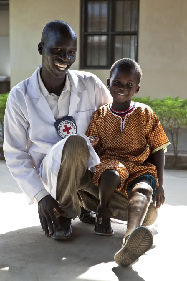 2012. Juba physical rehabilitation centre co-run by the ICRC. A six-year-old amputee with a physiotherapist from the centre where he received treatment and an artificial leg. 