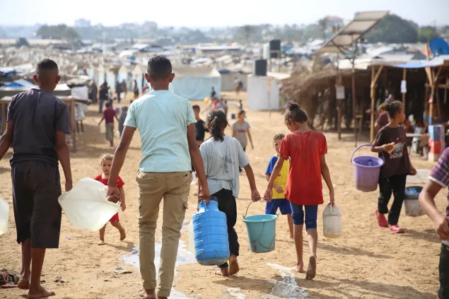 Distribution of drinking water to displaced persons at one of the shelters in Deir al-Balah, in the central Gaza Strip, through a partnership between the ICRC and the Coastal Municipalities Water Utility (CMWU)