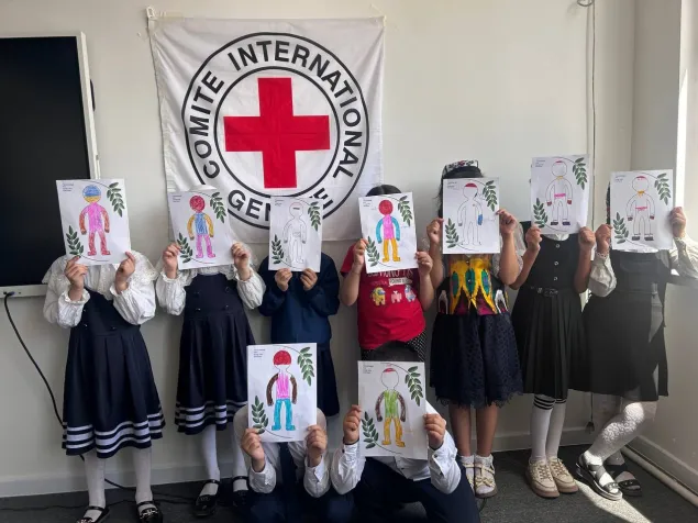 Children during an ICRC focused psychosocial support session hold up “body-mapping of emotions” drawings, a tool that helps children connect emotions with bodily sensations and communicate how they are feeling. Tashkent, Uzbekistan. 