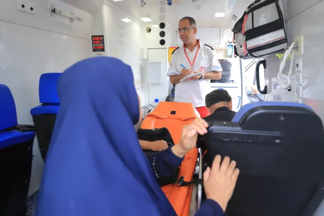 Jaber Zidan, who works with the Palestine Red Crescent Society (PRCS) in a PRCS ambulance checking names of patients before they move to the crossing.