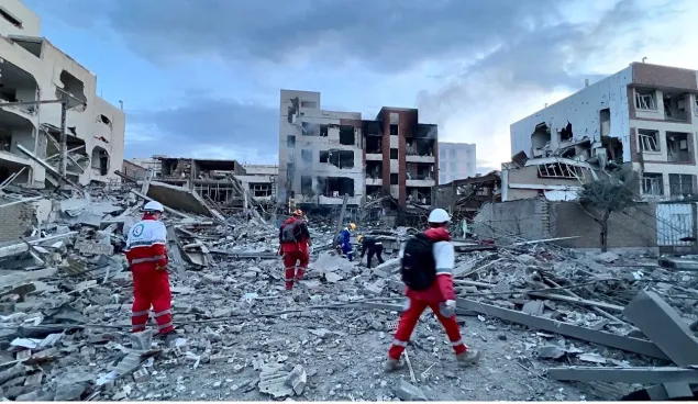 IRCS Rescue and Relief Organization first responders provide assistance at the site of a damaged residential area in western Tehran, 2026.