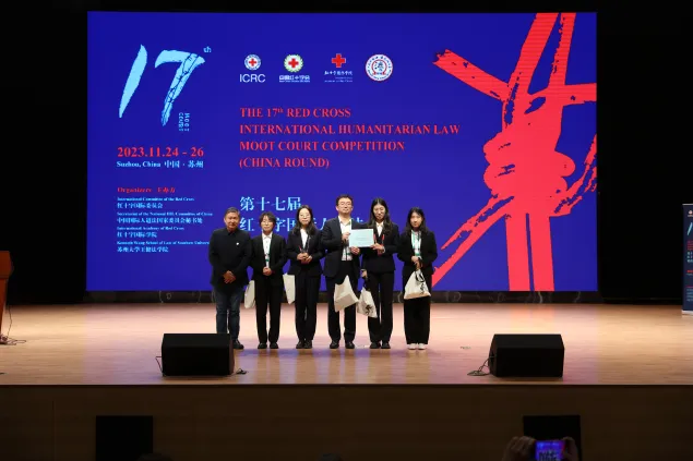 在2023年第十七届红十字国际人道法模拟法庭竞赛期上，吉林大学代表队获得亚军，于润田(左三)和队友一起上台领奖。