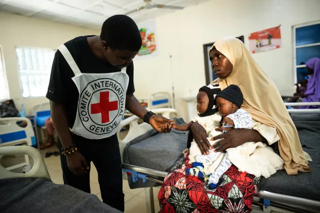 Zulaiha Mohammed, a mother of twins from Muda, with an ICRC staff, seeks medical attention for for her six-month-old twin daughter, Huseina Ahmadu, who is suffering from malnutrition, at Mubi Stabilization Center in Mubi, Northeast Nigeria.