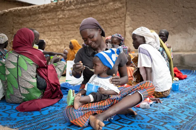 A mother feeds her child Tom Brown, a nutritional supplement provided by the ICRC to children under five years to help improve their health and nutritional status.
