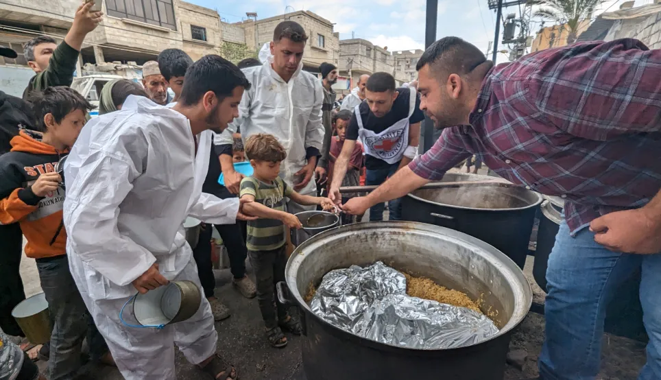 Pessoas buscam comida numa cozinha comunitária