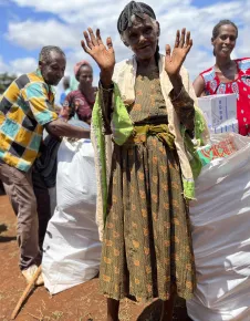 Woman at Ethipoian Red Cross Society distribution of food supplies and essential household items waves to the camera Woman at Ethipoian Red Cross Society distribution of food supplies and essential household items waves to the camera