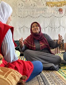 ICRC staff in Aleppo with a woman sitting on the ground