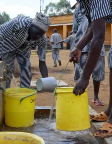 Inmates at a Prison in Kenya fetching clean water following a successful water systems upgrade by the Nairobi Regional Delegation.