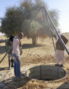Ghataye. Des hommes observent les travaux de fonçage d'un puits.