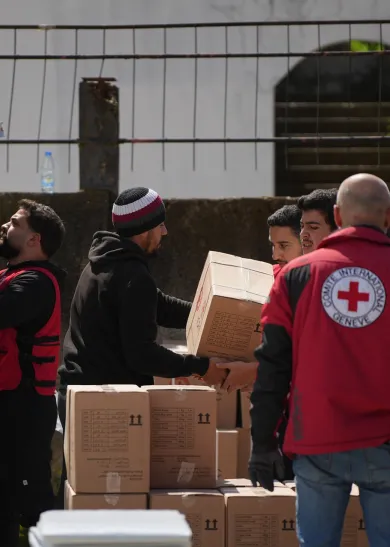 Staff from the International Committee of the Red Cross unloading a truck with aid parcels.