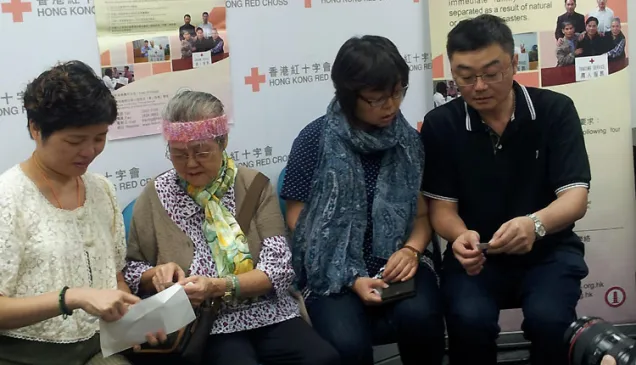 黄氏家庭在互相分享丁兰儿时的照片。(由左至右)黄丁兰、丁兰母亲、丁兰姐姐及弟弟。