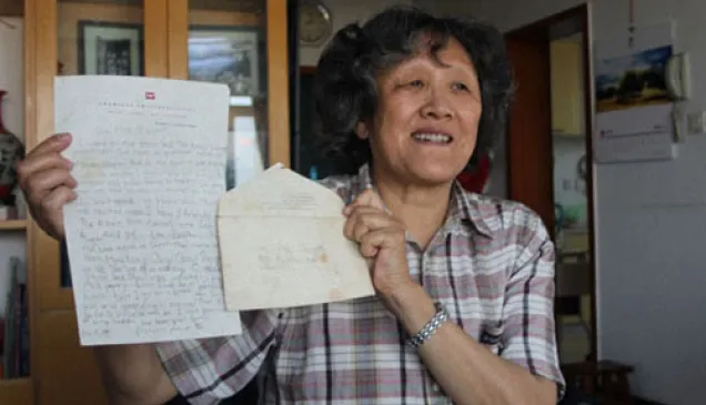 葛运培向记者展示母亲何怡贞当年写的25个字的信。